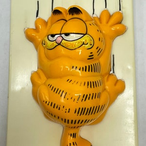 May include: A white ceramic mug with a black handle and the text "But First, Coffee" in a black, bold font. The mug is on a white surface.