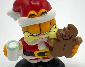 Gorgeous collectible and vintage ornament as Garfield as Santa Claus . Cat, orange, eating cookie, milk.