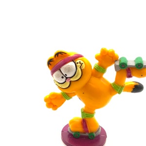 Vintage Garfield rolling skates figurine, cat, orange.