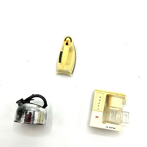 May include: A set of three miniature kitchen appliances: a yellow iron, a silver kettle, and a yellow coffee maker with the text "Le Coffee".