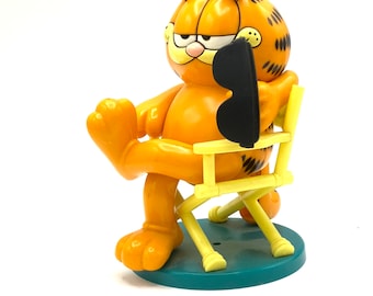 Gorgeous collectible and vintage  Garfield is sitting in director’s chair, With glasses, plastic, tall.