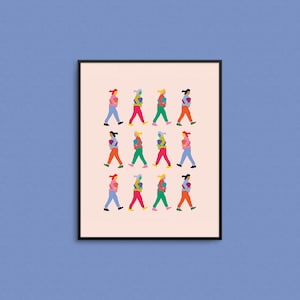 May include: A framed illustration of 12 people walking in a line, each carrying a colorful object. The people are wearing different colored clothing and have different hairstyles. The background is a light pink color.