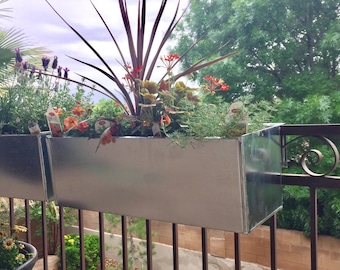 Metal planter boxes that set on patio railing.