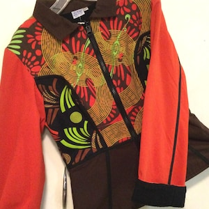 May include: A red, brown, and black patterned jacket with a zipper closure. The jacket has a black collar and black trim on the sleeves.