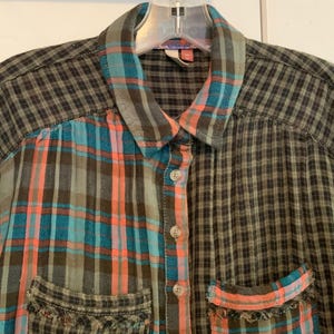 May include: A long-sleeved plaid shirt with a patchwork design. The shirt is made of a soft, comfortable fabric and features a button-up closure. The shirt is available in a variety of colors, including green, blue, and orange.