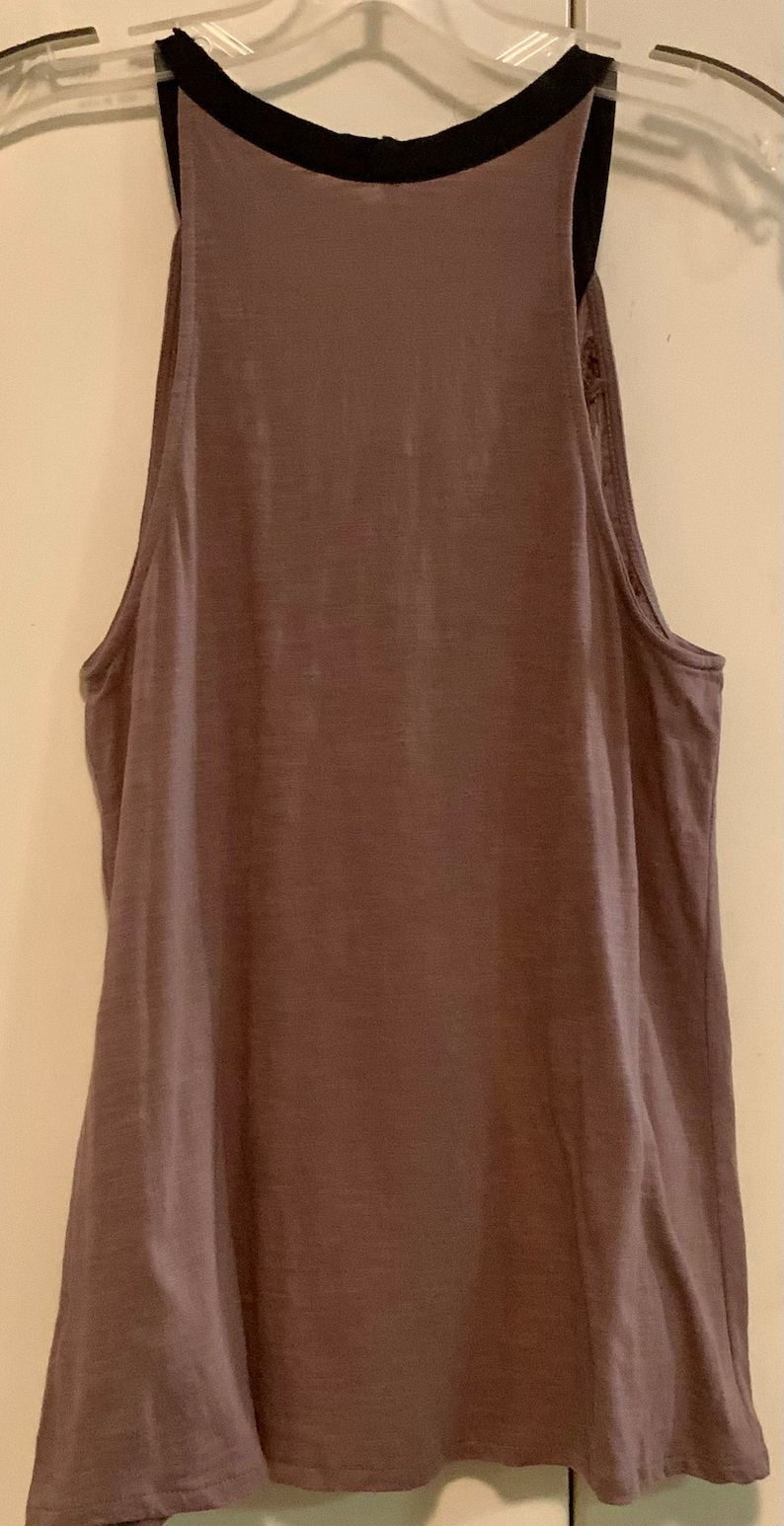 May include: A mauve sleeveless tank top with a black trim around the neckline.