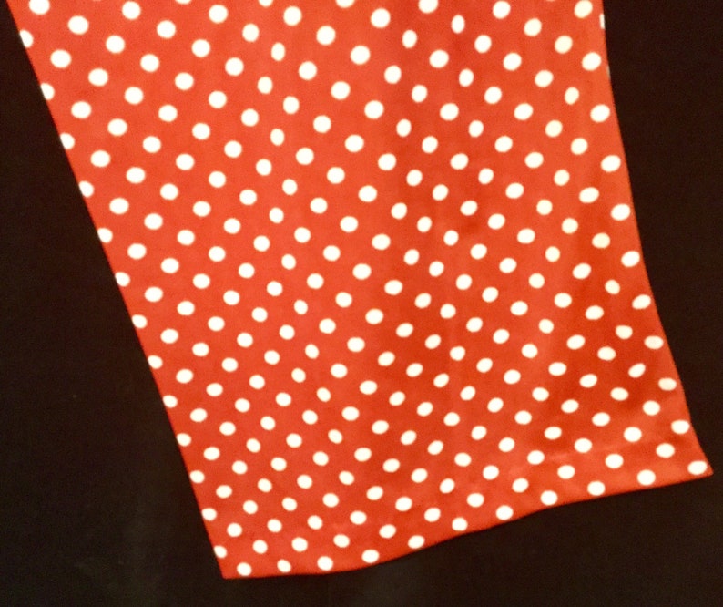 May include: Red fabric with a white polka dot pattern.