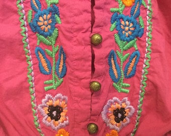 May include: Pink fabric with colorful embroidered flowers and green leaves. The fabric has a button closure.