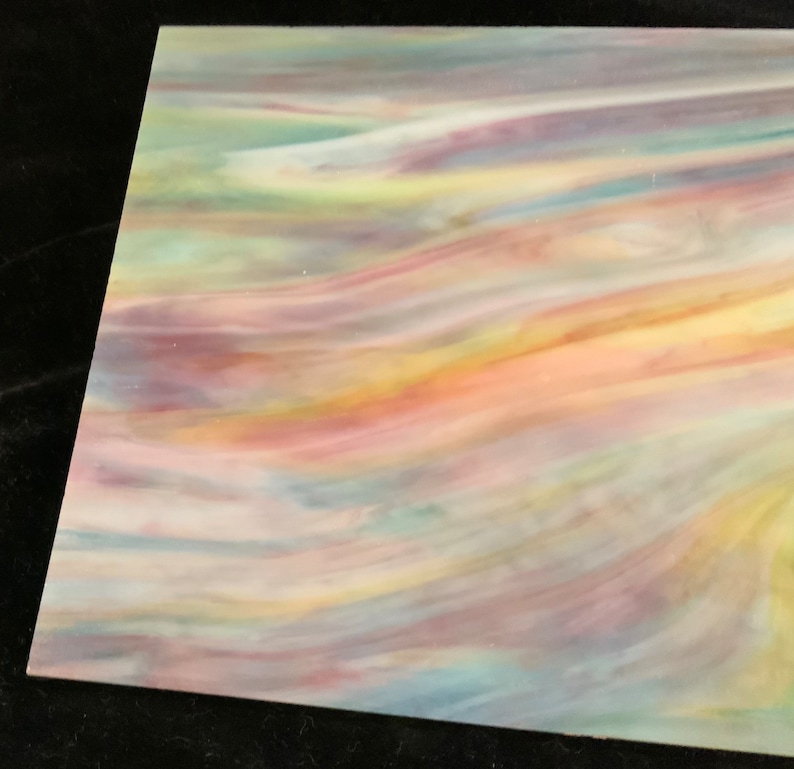 May include: A sheet of iridescent glass with a swirling pattern of pink, yellow, blue, and green colors.