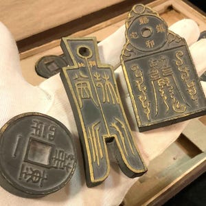May include: Three antique Chinese bronze plaques with gold lettering. The plaques are rectangular and have a dark brown patina. The lettering on the plaques is in Chinese characters.