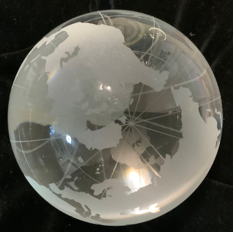 Op de afbeelding: Een matglazen globe met een witte gegraveerde wereldkaart. De globe is helder en heeft een lichte blauwe tint.