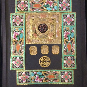 May include: A framed artwork with a black background and intricate gold and colored paper cutouts. The artwork features a central square with a smaller octagon inside, surrounded by four smaller squares. The artwork is decorated with floral motifs and the Chinese character for "double happiness" appears in the center.