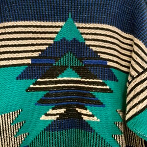 May include: A blue, green, white, and black knitted sweater with a geometric pattern.