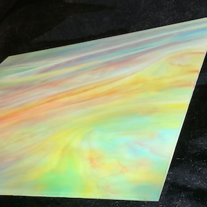 May include: A sheet of iridescent glass with a swirling pattern of yellow, orange, pink, blue, and green colors.
