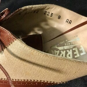 May include: Brown leather and canvas shoes with laces. The inside of the shoe has the text "FERRARE FLORENCE ITALY" and size information: "5 1/2 223 8 AA".