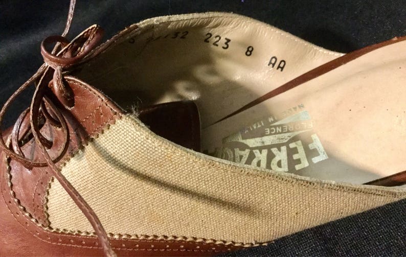 May include: Brown leather and canvas shoes with laces. The inside of the shoe has the text "FERRARE FLORENCE ITALY" and size information: "5 1/2 223 8 AA".