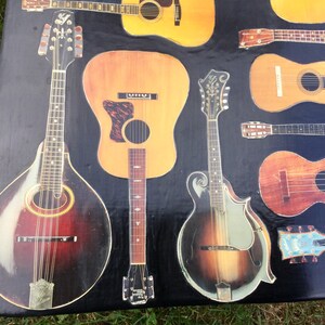 Op de afbeelding: Een verzameling vintage akoestische gitaren en mandolines met verschillende hout afwerkingen en inlays. De instrumenten zijn gerangschikt op een zwart oppervlak.
