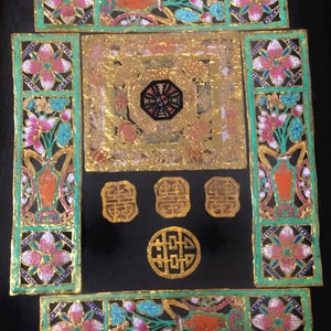 May include: A black square frame with gold and green accents. The frame is decorated with floral patterns and Chinese characters. The center of the frame features a gold octagon with a black center.