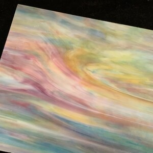 May include: A sheet of iridescent glass with swirling patterns of pink, yellow, blue, and green.