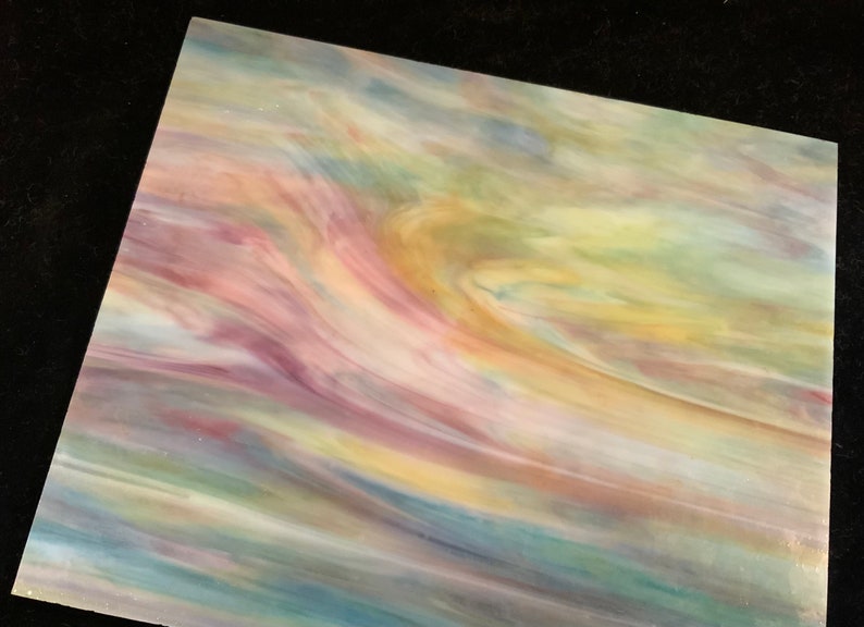 May include: A sheet of iridescent glass with swirling patterns of pink, yellow, blue, and green.