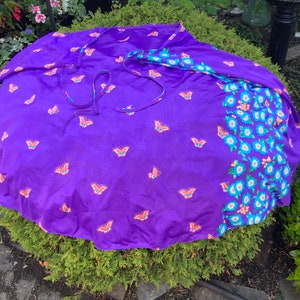 Op de afbeelding: Een paarse wikkelrok met een vlinderprint en een bloemenprint aan de ene kant.