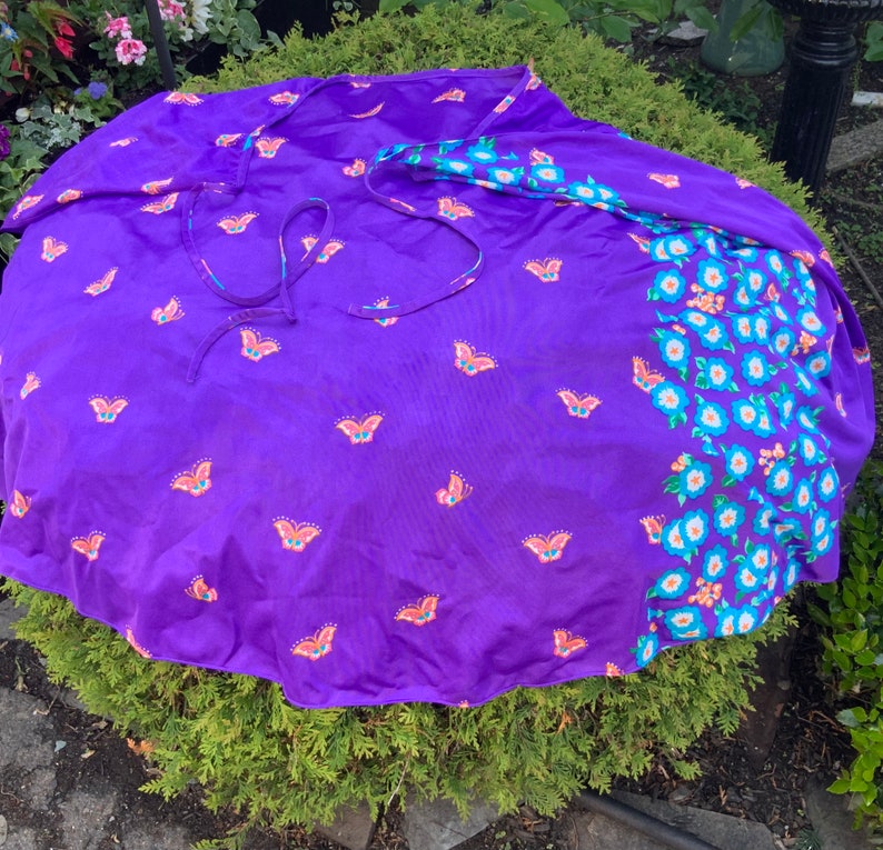 Op de afbeelding: Een paarse wikkelrok met een vlinderprint en een bloemenprint aan de ene kant.