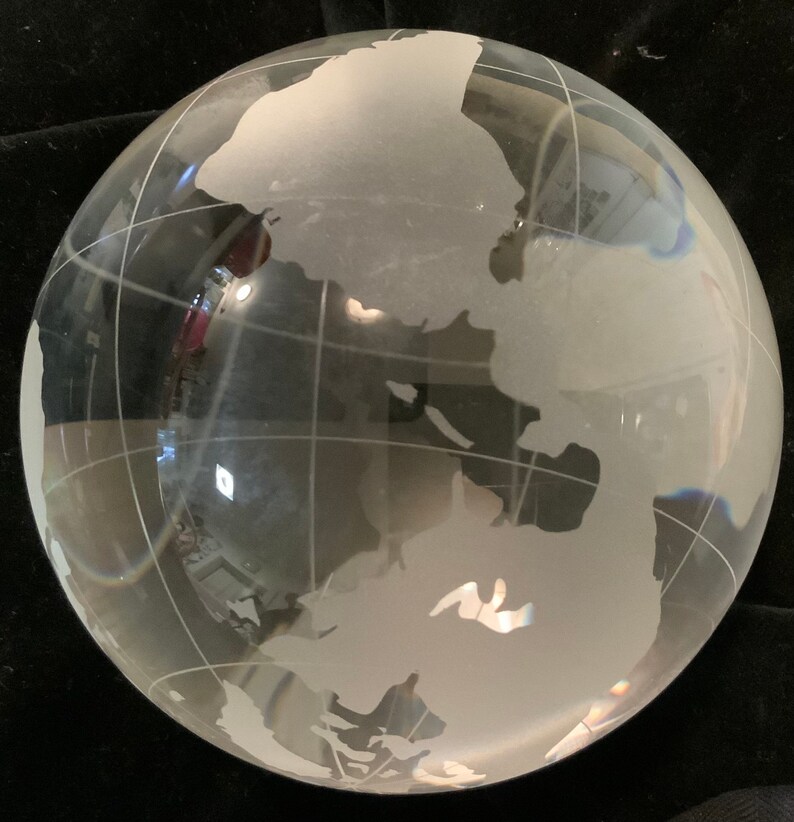 Op de afbeelding: Een heldere glazen globe met een gematteerde gegraveerde wereldkaart. De globe is een decoratief stuk met een gematteerde afwerking.