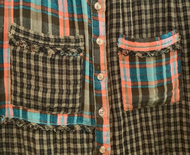May include: A plaid shirt with a patchwork design. The shirt has two pockets with frayed edges and a button-up front.