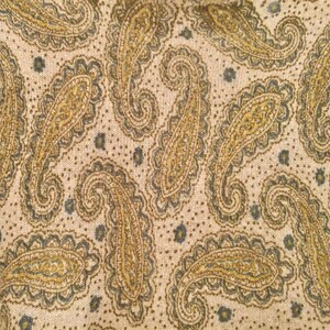 May include: A beige fabric with a paisley pattern in shades of brown and gray.