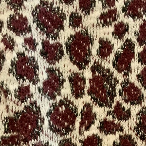 Puede incluir: Primer plano de una tela de punto marr&oacute;n y blanca con un estampado de leopardo brillante.