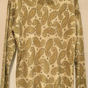 May include: A long-sleeved sweater with a paisley pattern in shades of gold and cream.