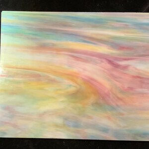 May include: A sheet of iridescent glass with a swirling pattern of blue, green, yellow, and pink colors.