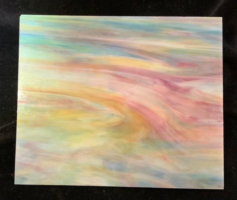 May include: A sheet of iridescent glass with a swirling pattern of blue, green, yellow, and pink colors.