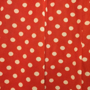 May include: Red fabric with a white polka dot pattern.