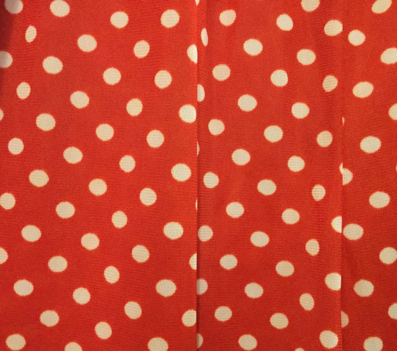 May include: Red fabric with a white polka dot pattern.
