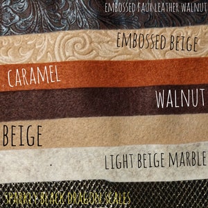 May include: A close-up of ten different fabric swatches. The swatches are arranged vertically from top to bottom. The swatches are labeled with the following names: Embossed Faux Leather Black, Embossed Faux Leather Walnut, Embossed Beige, Caramel, Walnut, Beige, Light Beige Marble, Sparkly Black Dragon Scales, Iridescent Pink White Dragon Scales.