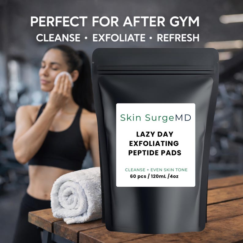 Może przedstawiać: Czarna torebka z białą etykietą z napisem "Skin SurgeMD" i "LAZY DAY EXFOLIATING PEPTIDE PADS". Etykieta zawiera r&oacute;wnież "CLEANSE + EVEN SKIN TONE". Torebka leży na drewnianej powierzchni.