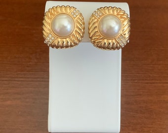 Pendientes de clip con perlas Mabe blancas y cuadradas en tono dorado con logotipo de cisne de Swarovski. Clip-Ons en tono dorado y perla blanca. Joyería firmada por Swarovski.