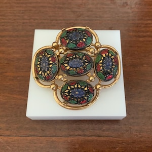 Vintage SARAH Coventry "Light of the East" flerfärgad blommig emaljbrosch i guldfärgat kors. Vintage Sarah Coventry smycken från 1960-talet
