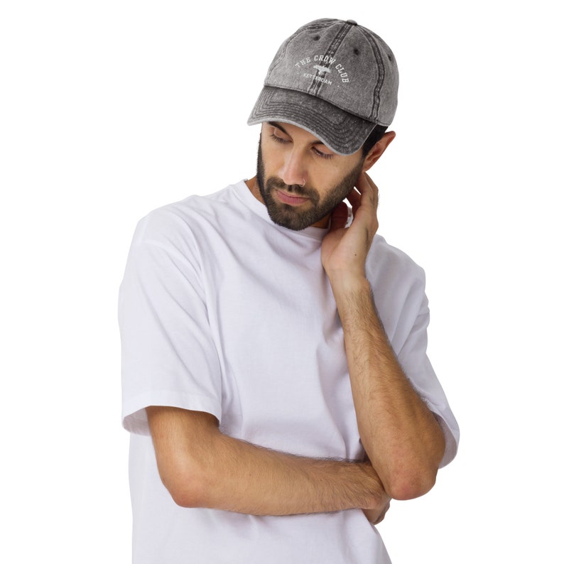 May include: A gray distressed baseball cap with white embroidery that reads "The Crow Club Est. 1978".
