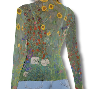 Puede incluir: Una blusa de manga larga con un diseño de pintura floral en tonos verdes, amarillos, rojos y blancos. La blusa tiene un cuello alto y se combina con pantalones cortos de mezclilla. La obra de arte recuerda a un campo de flores.