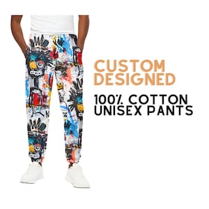 May include: Unisex trousers made from 100% cotton with a colourful abstract design. The trousers have a drawstring waistband and a relaxed fit. "CUSTOM DESIGNED 100% COTTON UNISEX PANTS" is written in the image.