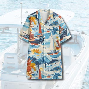 May include: A white short-sleeved button-down shirt with a blue, white, and red nautical print featuring sailboats and waves.