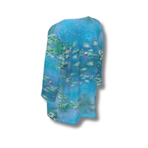 Puede incluir: T&uacute;nica de manga larga en tonos azules, verdes y morados, con un estampado que recuerda a un estanque de nen&uacute;fares. La tela parece suave y fluida, con cuello redondo y corte holgado.