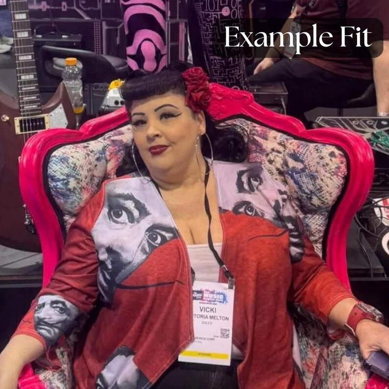 Puede incluir: Una chaqueta roja con un dise&ntilde;o de retrato en las mangas y la parte delantera. La chaqueta se usa sobre una camiseta blanca. El fondo incluye una silla rosa y una guitarra. Una etiqueta con el nombre dice "Vicki Victoria Melton".