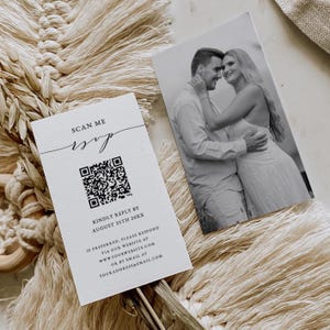 May include: A white card with a black and white QR code and the text "SCAN ME RSVP" in black script. The text "KINDLY REPLY BY AUGUST 25TH 20XX" is in black text. Below that is the text "IF PREFERRED, PLEASE RESPOND VIA OUR WEBSITE AT WWW.YOURWEBSITE.COM OR BY EMAIL AT YOURADDRESS@EMAIL.COM" in black text.