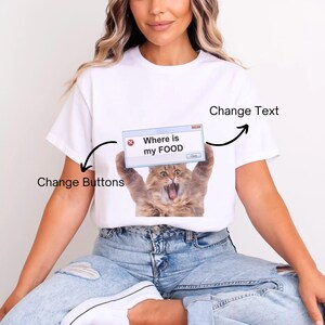 May include: White t-shirt with a graphic of a cat holding a pop-up window. The window reads "Where is my FOOD". The cat has a surprised expression. The pop-up window has an "X" and a "Close" button.