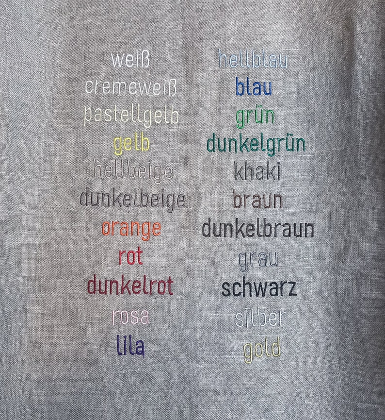 May include: A fabric swatch with a variety of color names embroidered in different colors, including white, cream, yellow, orange, red, pink, purple, blue, green, brown, gray, black, silver, and gold.