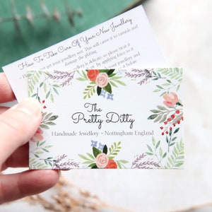 May include: A business card with floral designs and the text "The Pretty Ditty Handmade Jewellery ~ Nottingham England." A smaller card on top reads "How To Take Care Of Your New Jewellery."