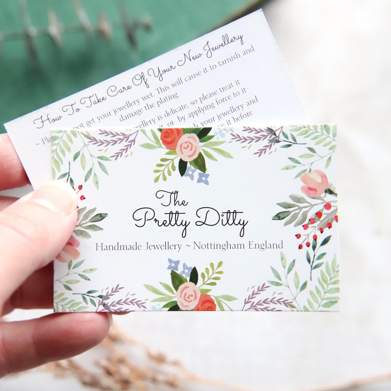 May include: A business card with floral designs and the text "The Pretty Ditty Handmade Jewellery ~ Nottingham England." A smaller card on top reads "How To Take Care Of Your New Jewellery."